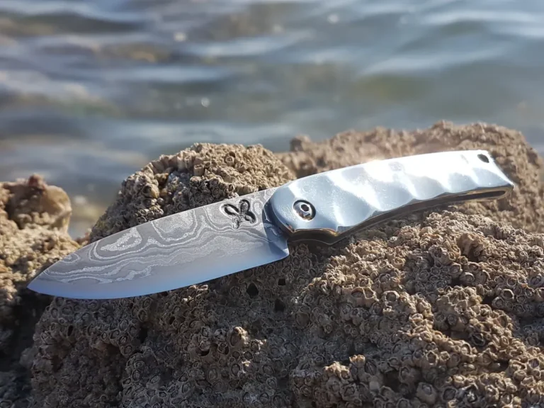 Couteau fixe forgé par l'Atelier Byro, posé sur un rocher