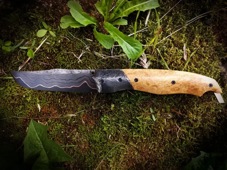 Couteau fixe Benjamin Rogez à lame damas, posé sur la mousse