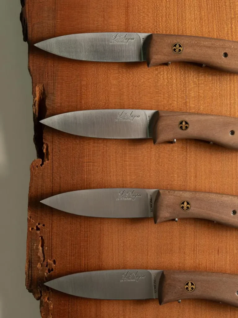 Couteaux de la Coutellerie du Maine-Anjou alignés sur du bois